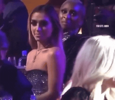 a woman in a strapless dress is sitting in the audience of a concert .