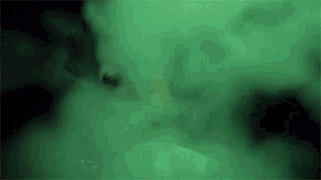 a close up of a green smoke coming out of a hole in the ground .