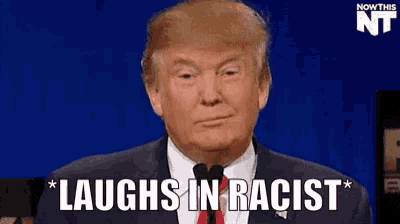 a man in a suit and tie is laughing in a racist speech .