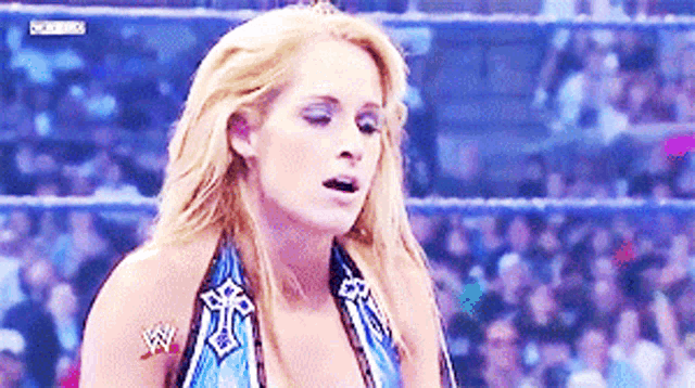 a woman in a wrestling ring has a tattoo on her arm that says wwe