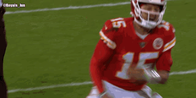 a football player wearing a helmet and a red jersey is running on a field .