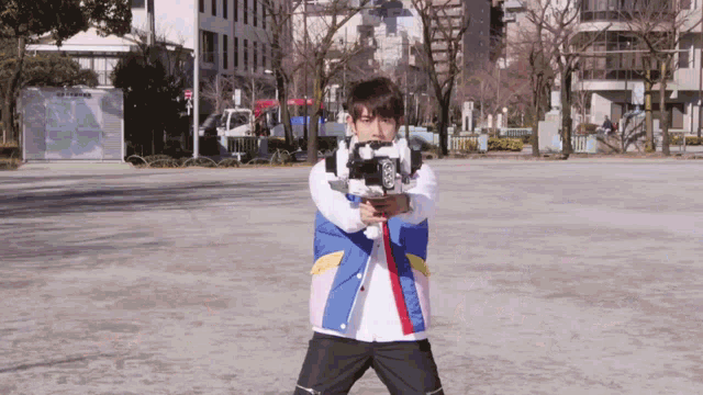 a man in a colorful jacket is holding a gun in a park with a sign in the background that says no parking