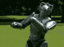 a person in a robot costume is standing in a field .