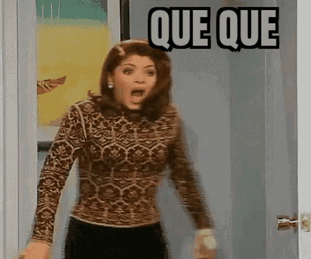 a woman in a leopard print shirt stands in front of a door with que que written on it