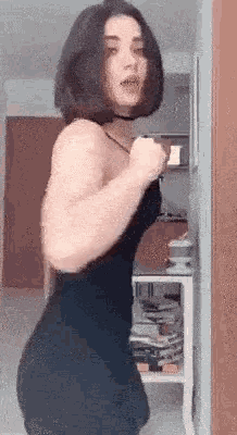 a woman in a black dress is dancing in a room .