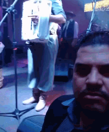 a man with a beard takes a selfie in front of a microphone