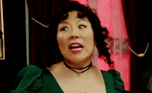 a woman wearing a green dress and a choker is making a funny face