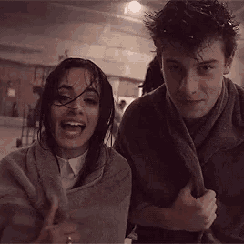 a man and a woman are wrapped in a blanket .