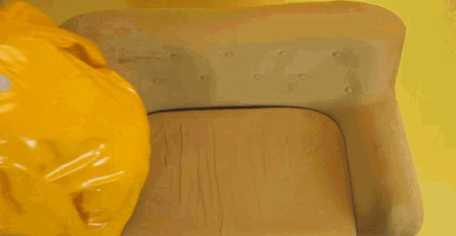 a woman is laying on a couch wearing yellow pants and a yellow raincoat
