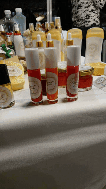 several bottles of lip gloss are lined up on a white table