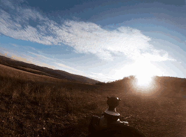 the sun shines brightly through the clouds above a field