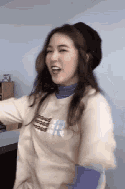 a woman wearing a hat and a t-shirt is dancing .