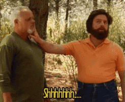 a man with a beard is touching another man 's neck and says shhhhh