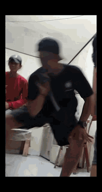a blurry picture of a man wearing a hat and a black shirt