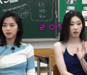 two girls are sitting in front of a chalkboard with the number 20 written on it