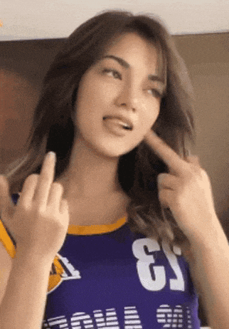 a woman wearing a purple jersey with the number 3 on it gives the middle finger