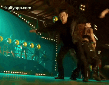 a man and a woman are dancing on a stage in front of a crowd .