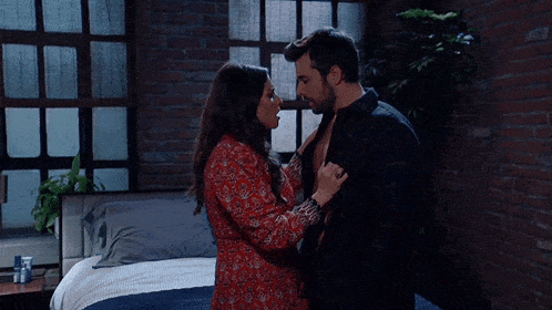 a man and a woman are kissing in a bedroom