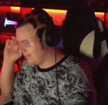 a man wearing headphones is sitting in a chair in front of a computer .