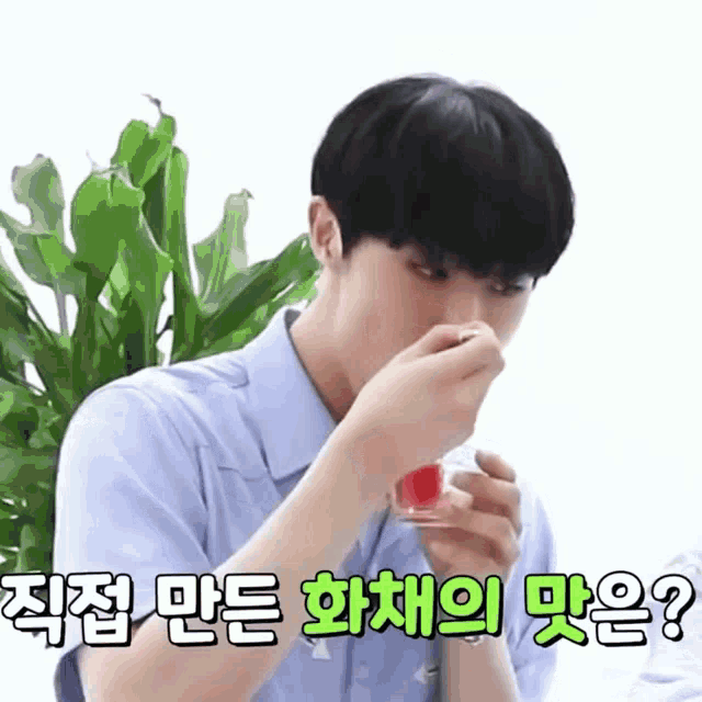 a man in a blue shirt is eating a strawberry from a small glass