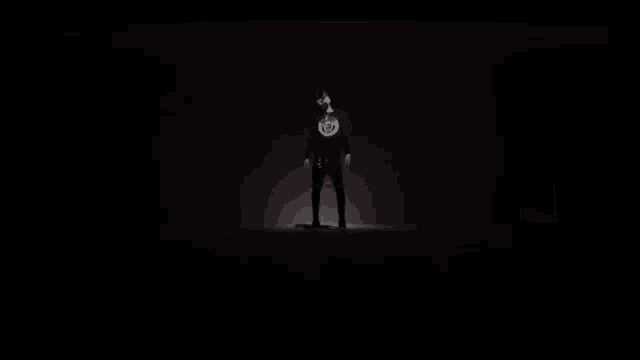 a man is standing in a dark room with a light on his head