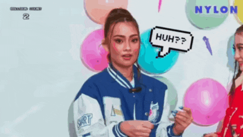 a woman in a blue and white jacket is holding balloons and a speech bubble that says huh