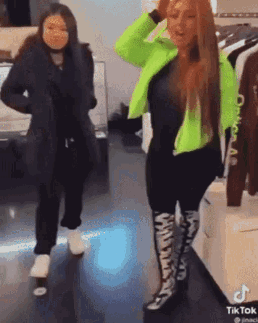 two women are standing next to each other in a clothing store .