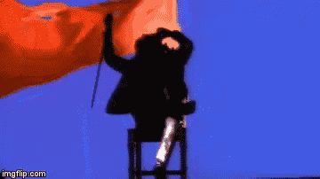 a man in a wheelchair is holding a parachute while standing on a chair .