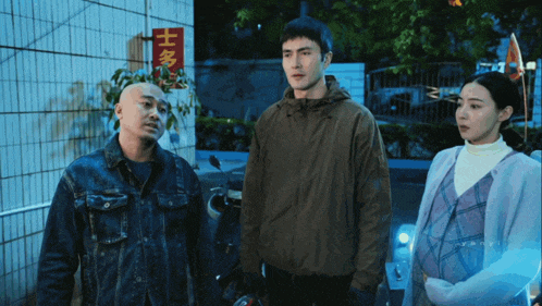 three people standing in front of a building with chinese writing
