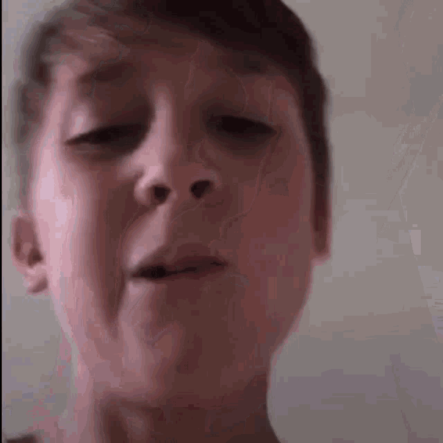 a young boy is making a funny face with his mouth open .