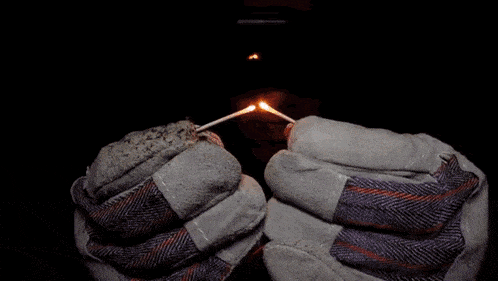 a person wearing a pair of gloves is holding a light bulb