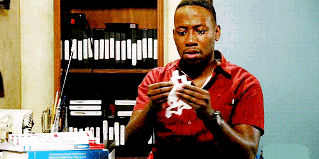 a man in a red shirt holds a piece of paper