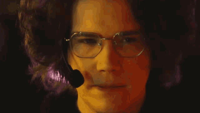 a man wearing glasses and a microphone on his face
