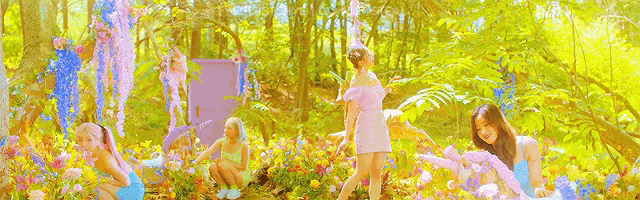 a group of women are standing in a field of flowers .