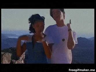 a man and a woman are standing on top of a mountain and giving the middle finger