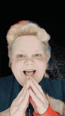 a woman with her mouth open and her hands folded