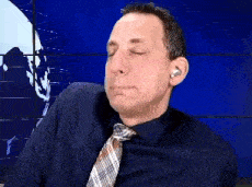 a man wearing a tie and ear buds is making a face