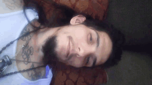 a man with long hair and a beard is laying down