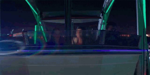 a man and a woman are riding a ferris wheel at night