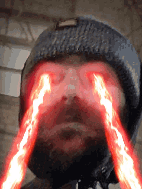 a close up of a man 's face with red eyes