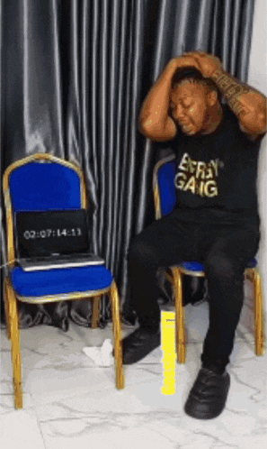a man wearing a shirt that says every gang is sitting on a chair