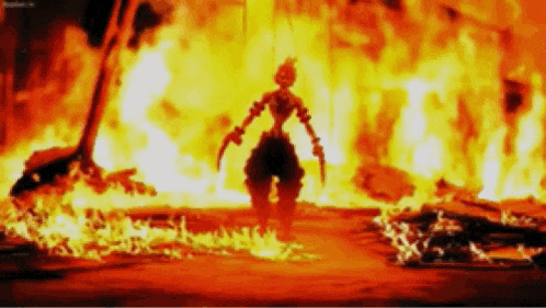 a person is standing in front of a large fire