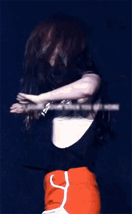 a woman in a black shirt and orange shorts dancing