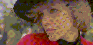 a woman wearing a hat and veil with dots on her face .