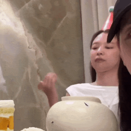 a woman wearing a party hat looks at a white bowl