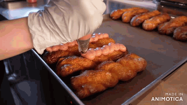 a bunch of donuts are on a tray that says made in animotica on the bottom