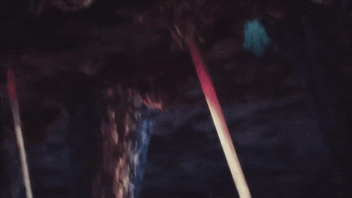 a person is standing in a cave with a sword and a hammer .