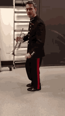 a man in a uniform is holding a trumpet