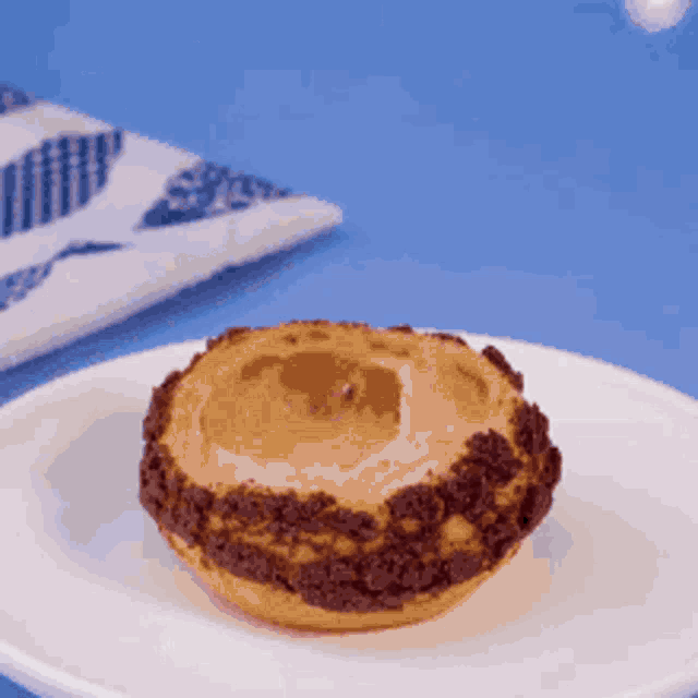 a pastry on a white plate with a napkin in the background