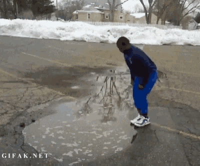 a man is jumping into a puddle of water with gifak.net written in the corner